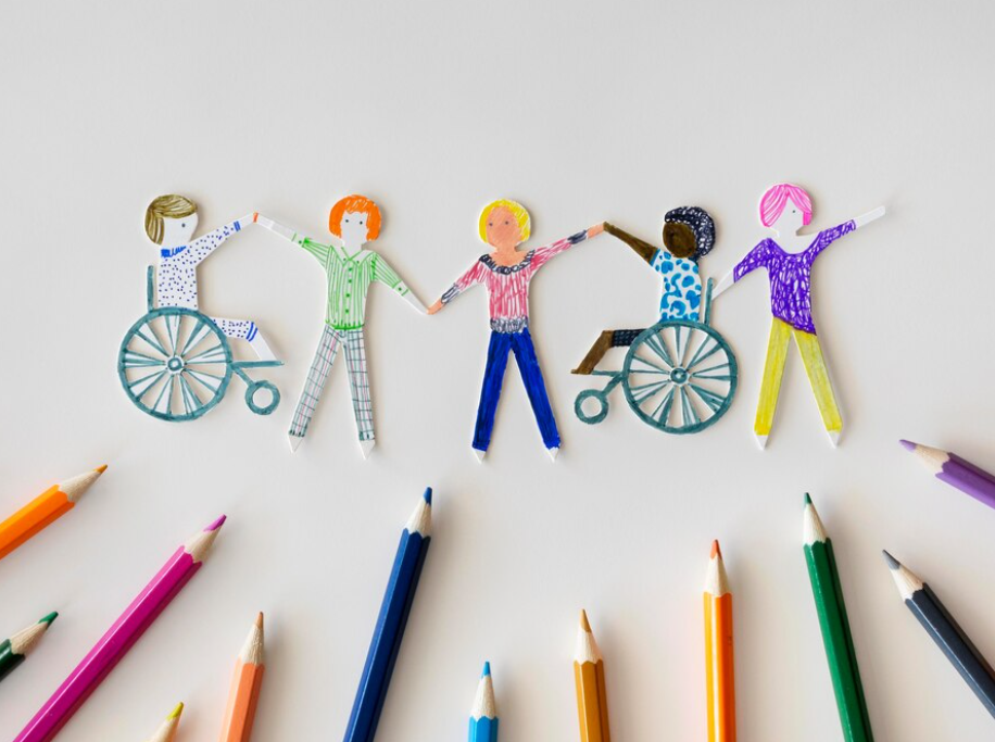 a group of people, two of them in wheelchairs, holding hands in unity against a backdrop of colored pencils.